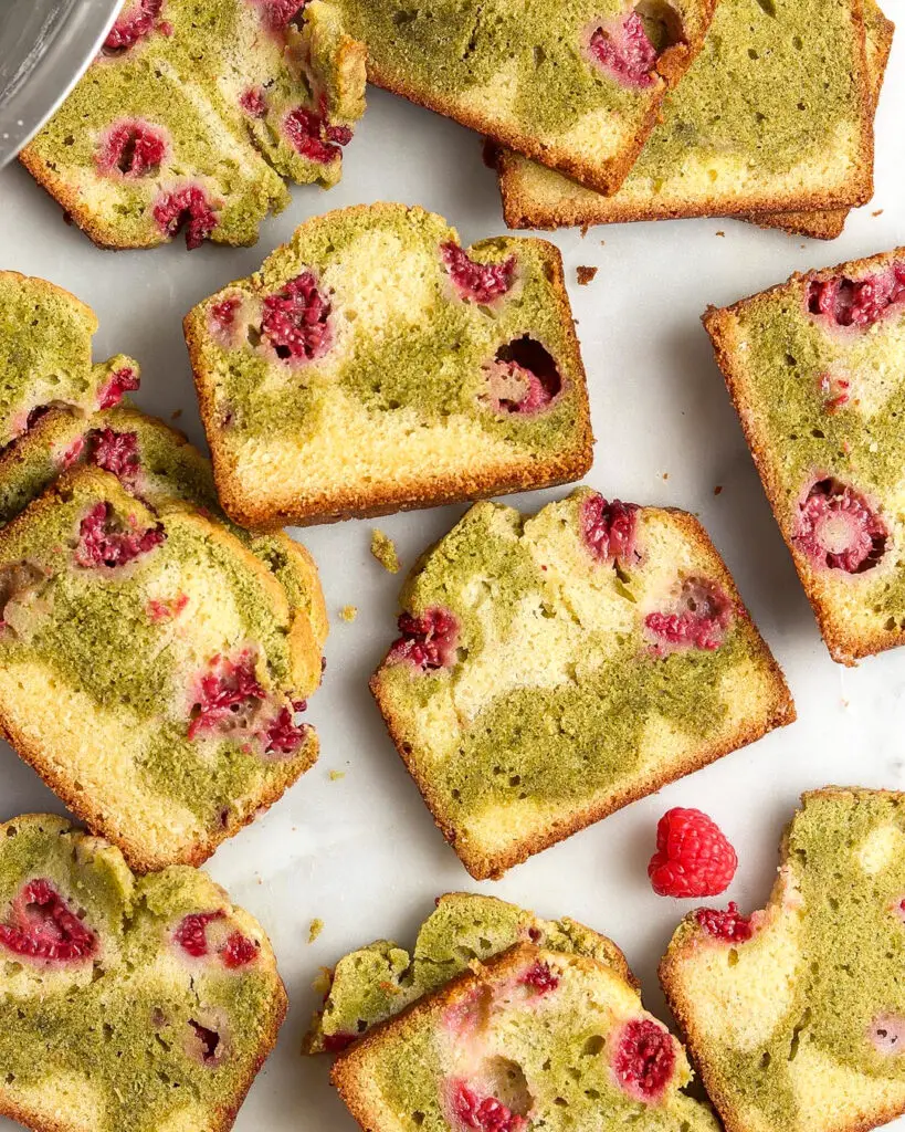 several slices of matcha raspberry swirl pound cake laid out on a white surface