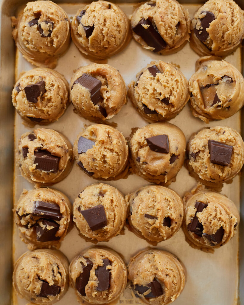 chocolate chip cookie dough balls scoops on a sheet tray 