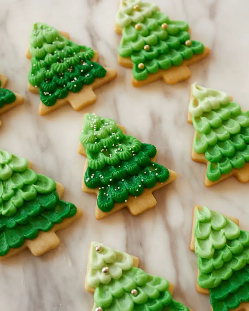 eight christmas tree sugar cutout cookies, frosted with an ombre green buttercream effect 