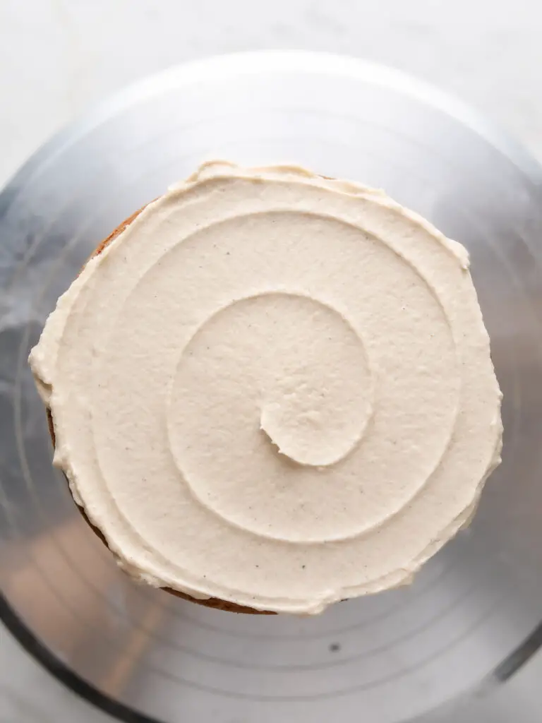 frosting and filling an apple spice layer cake