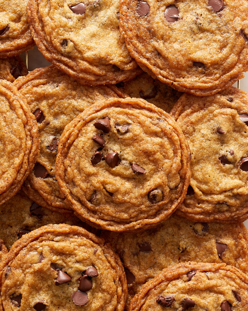 several crispy brown butter chocolate chip cookies stacked on each other 