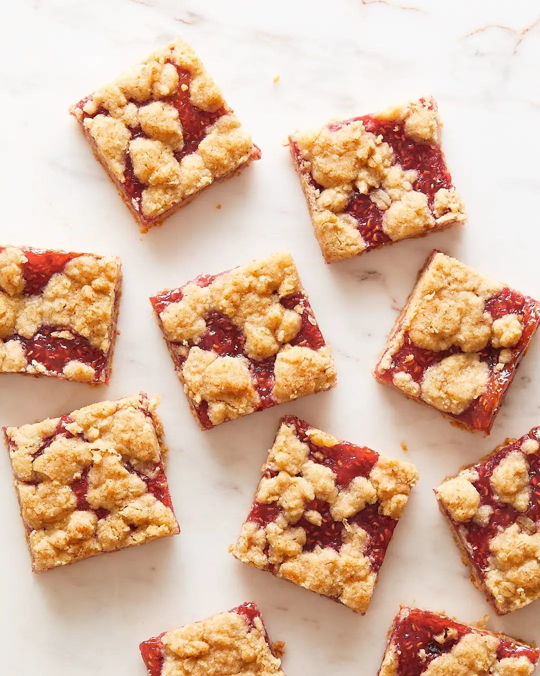 Slices of raspberry oat bars arranged on parchment paper