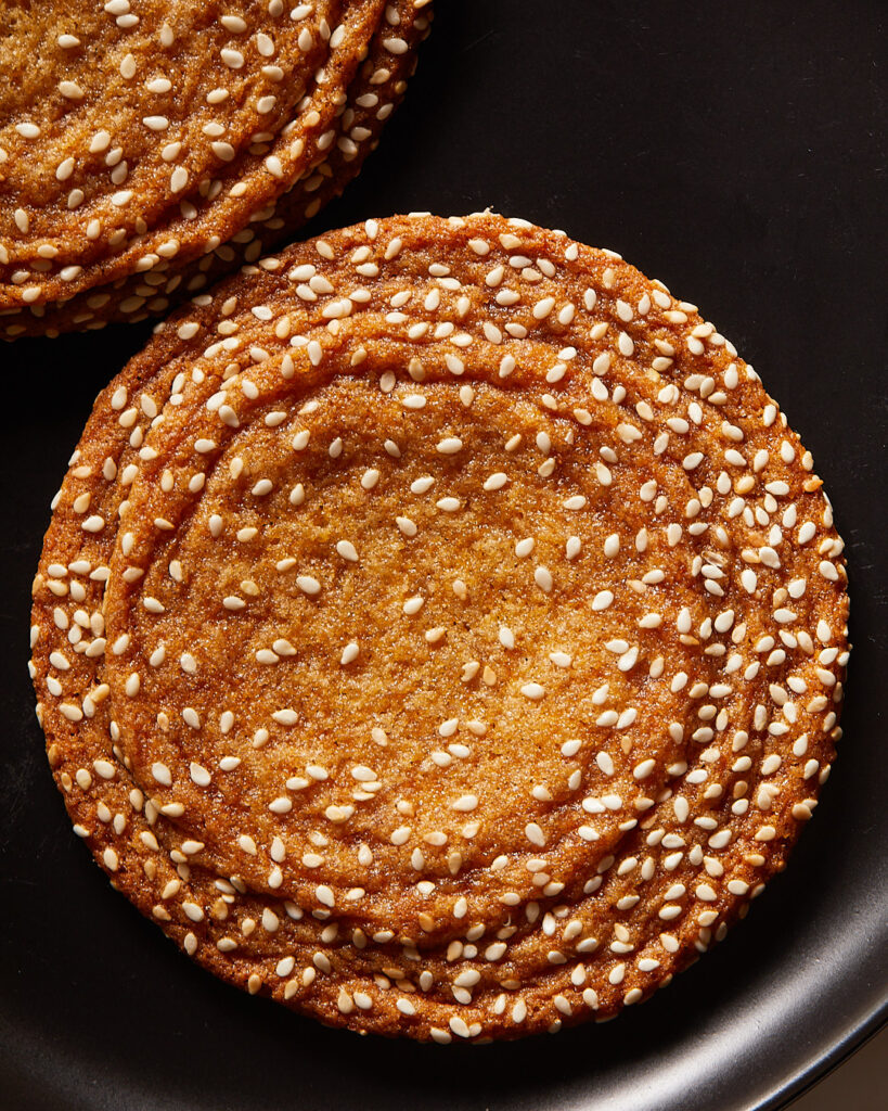 a large sesame honey cookies with crinkles along the edges 