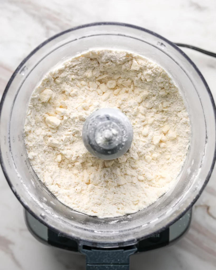 a food processor mixes flour and butter