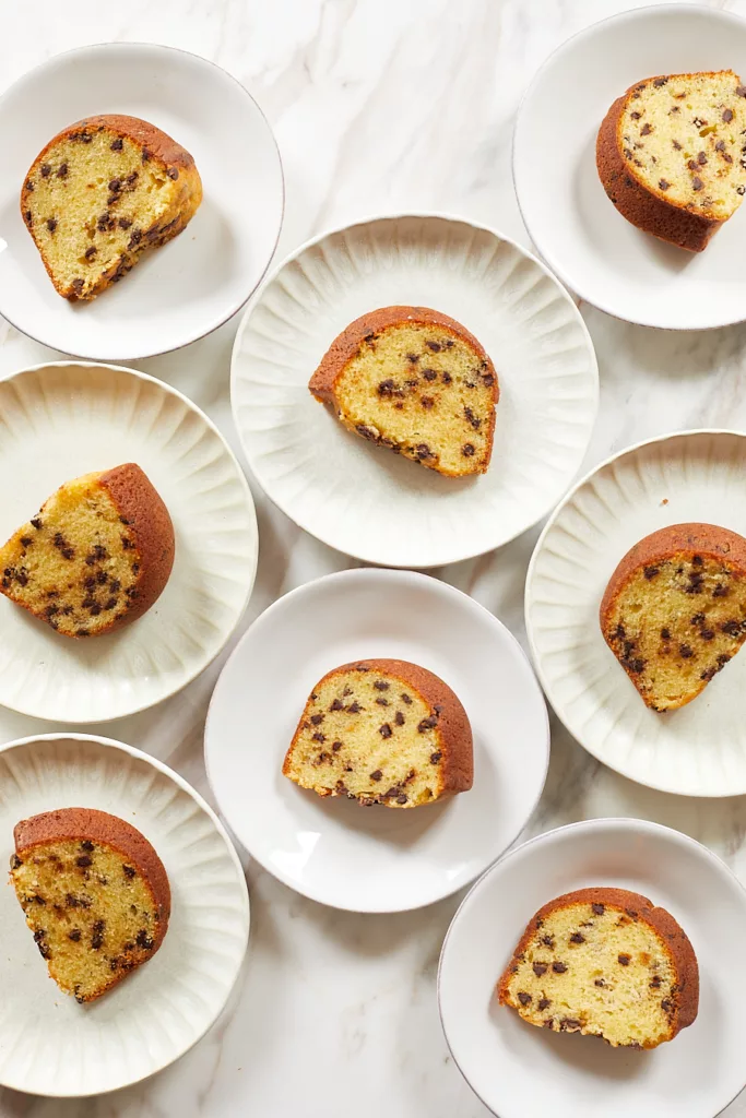 eight slices of sour cream chocolate chip bundt cake on white dessert plates