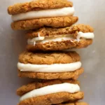 oatmeal sandwich cookies stacked sideways on a sheet tray