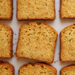 olive oil zucchini bread slices lined up on a marble surface