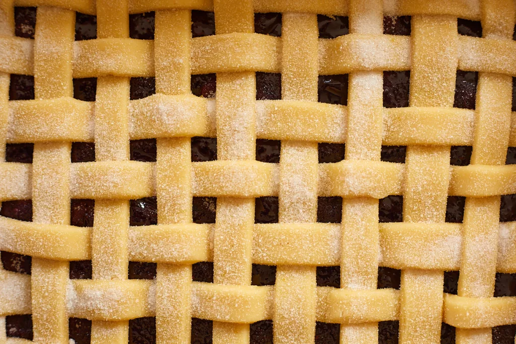 unbaked lattice crust tops a blueberry filling for blueberry pie bars