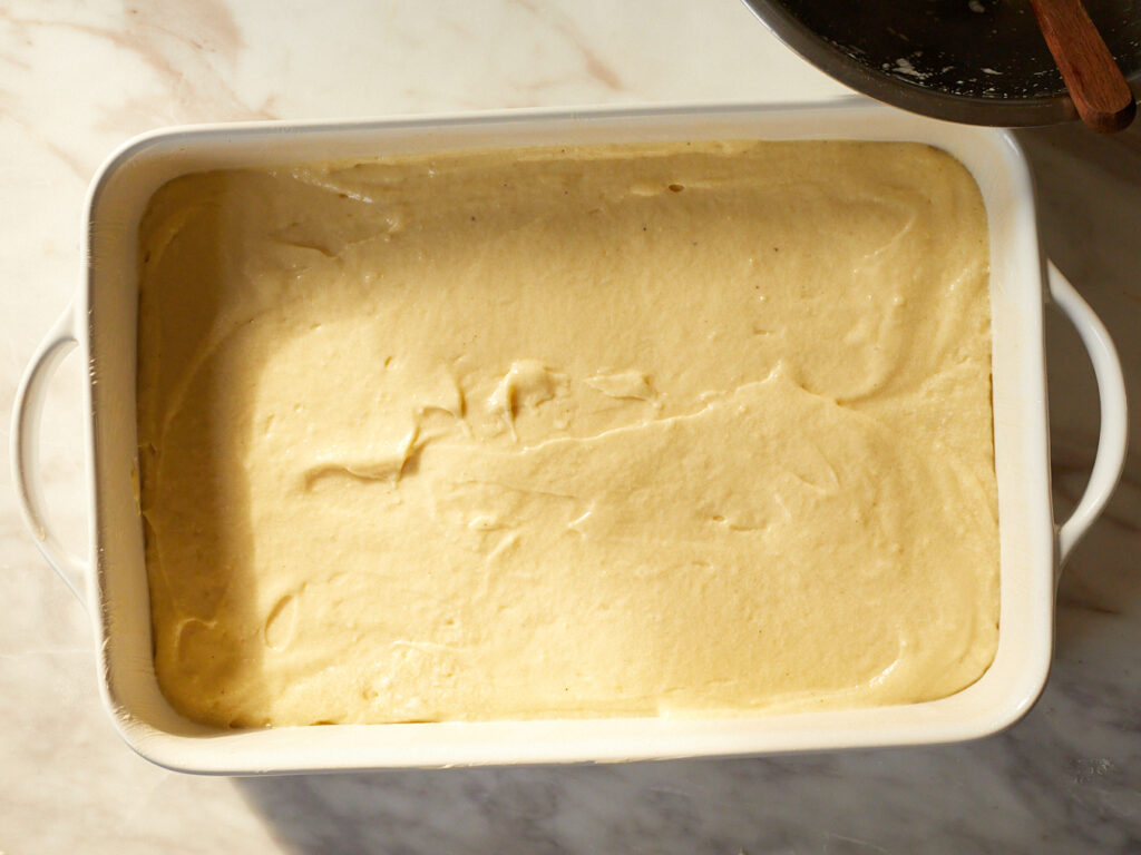 a ceramic 9x13 pan filled with yellow cake batter