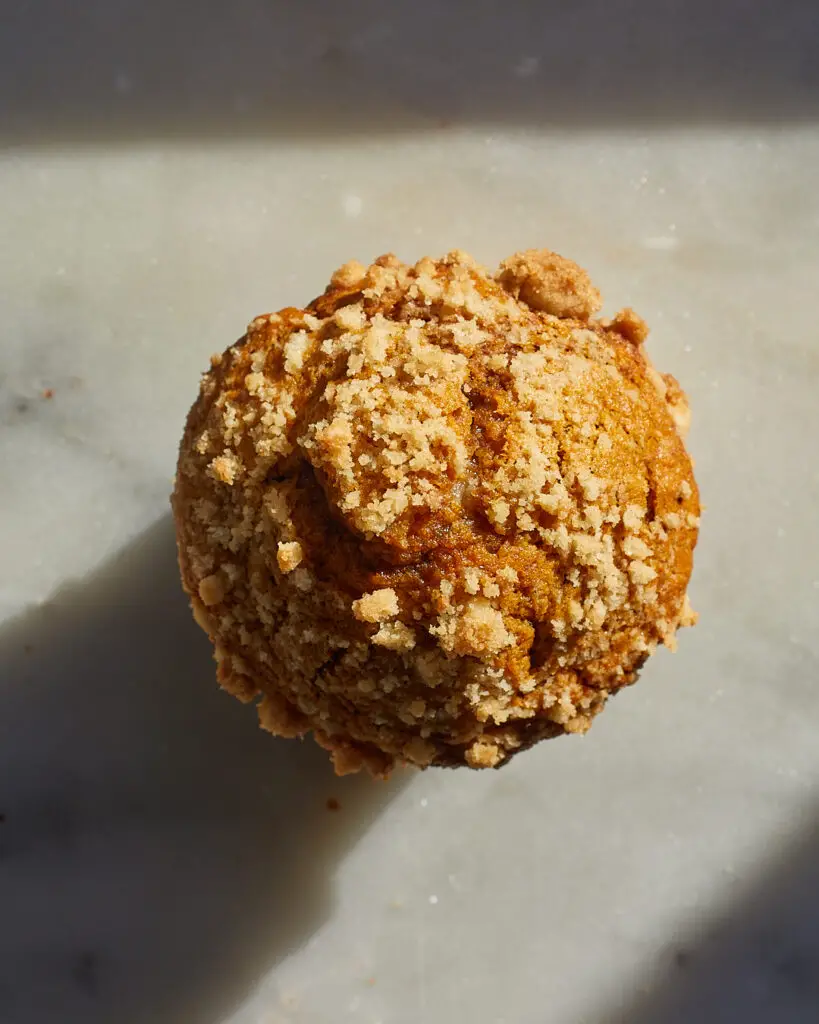 The top of a pumpkin muffin covered in streusel