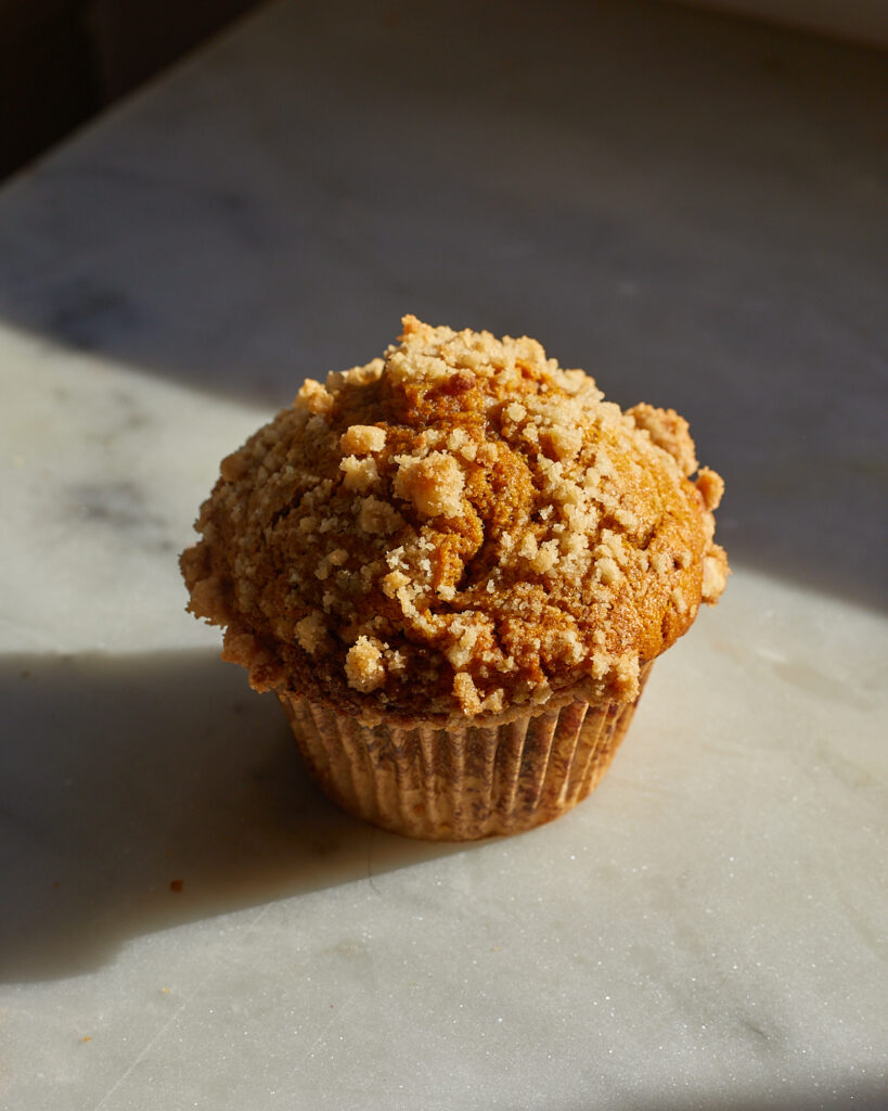 The top of a pumpkin muffin covered in streusel