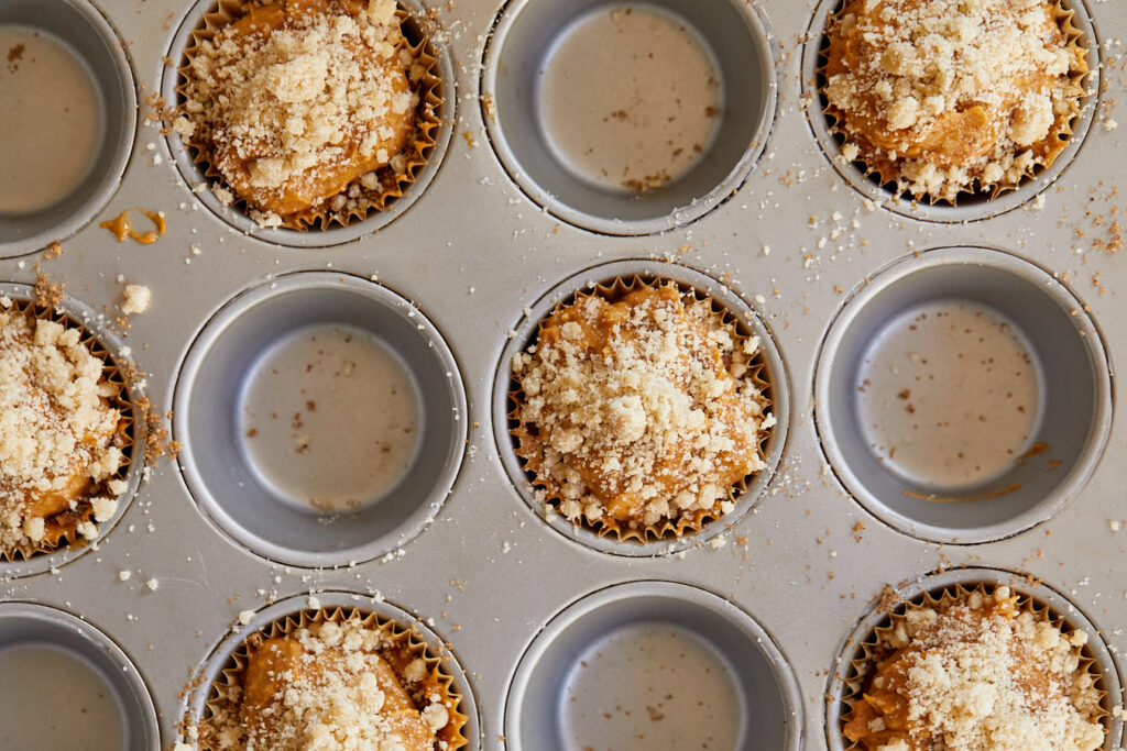 a muffin tin full of pumpkin muffin batter