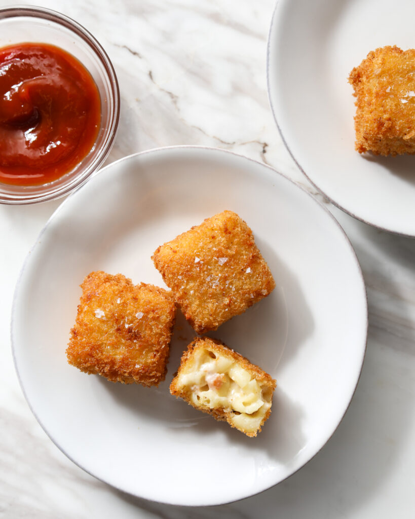 mac and cheese bite dipped in ketchup