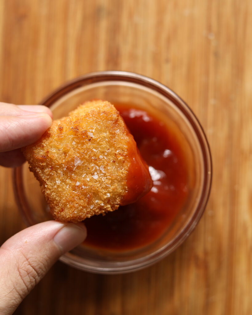 mac and cheese bite dipped in ketchup