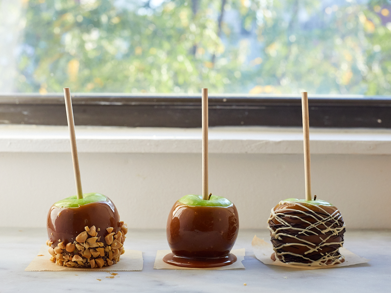 caramel apples decorated with chocolate peanuts and m&ms