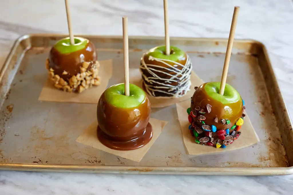 caramel apples decorated with chocolate peanuts and m&ms