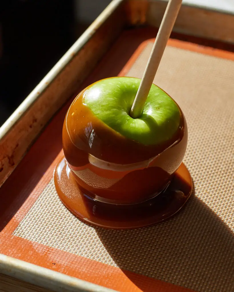 a caramel apple on a baking sheet