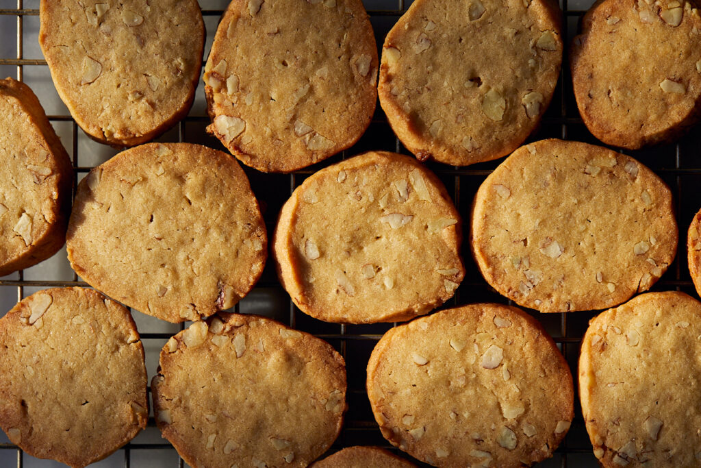 pecan shortbreads lined up like tiles on a wire rack in the evening sunlight