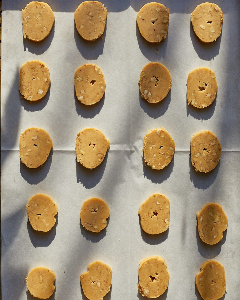 coins of pecan sandies shortbread dough on a sheet tray waiting to be baked