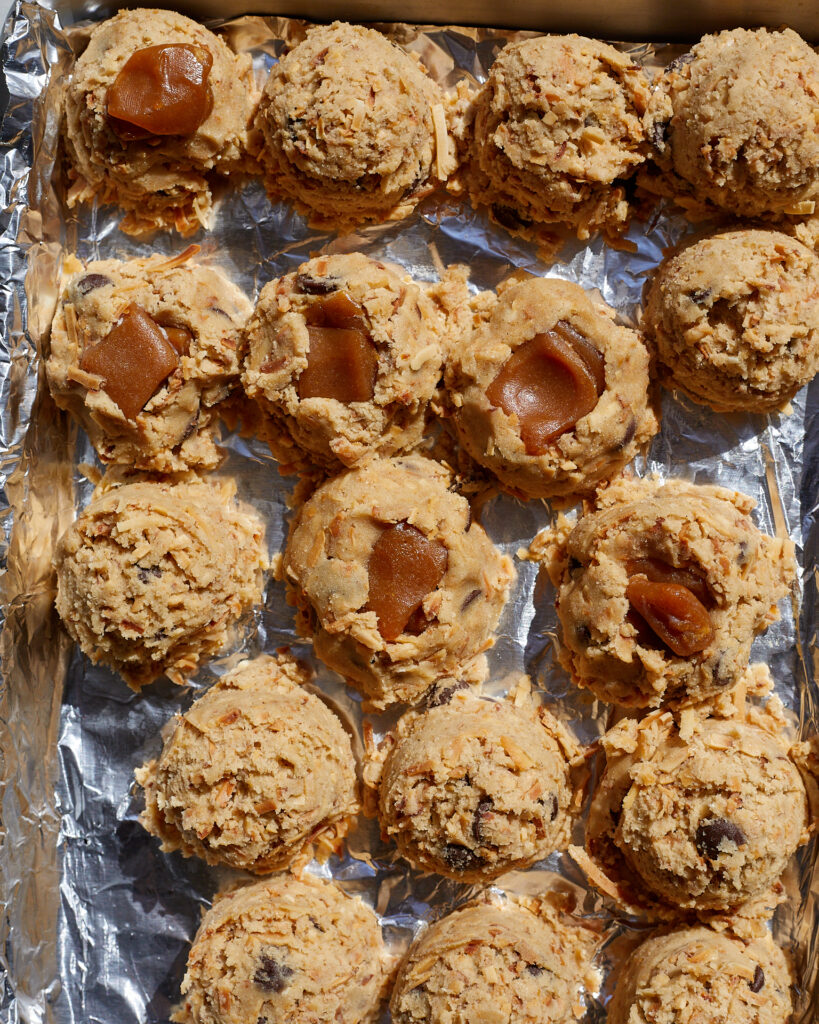 balls of cookie dough on a baking sheet lined with foil