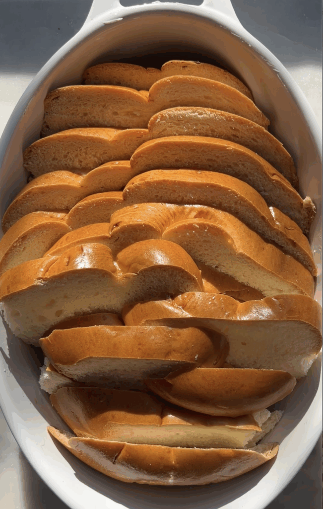 bread slices lined up in a tin for eggnog french toast bake