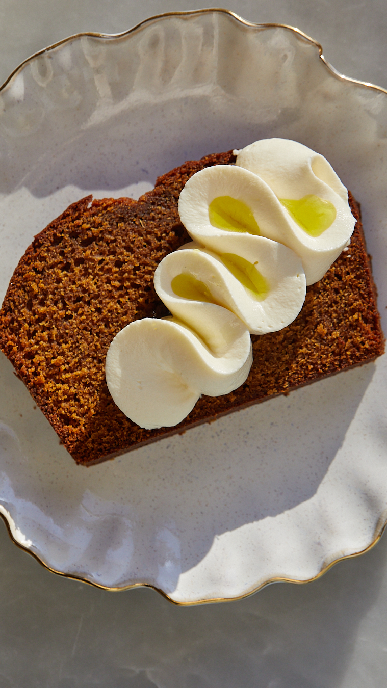 gingerbread loaf cake with a ribbon of mascarpone cream and a drizzle of olive oil on top