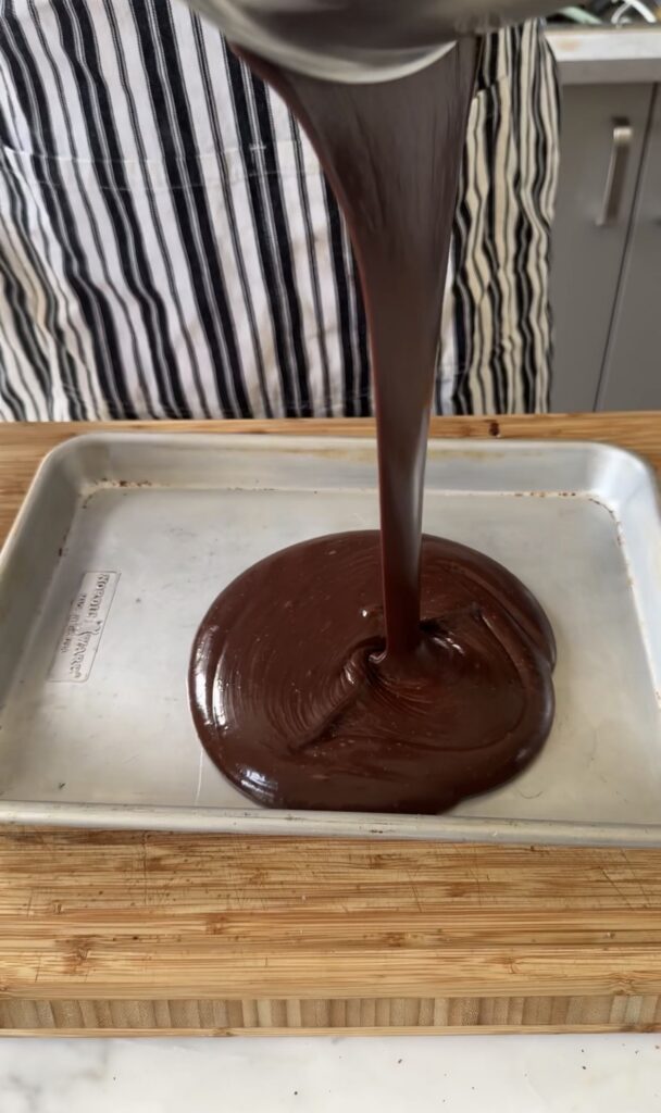 hot fudge is poured onto a sheet tray for chocolate buttercream